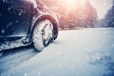 Car tires on winter road covered with snow