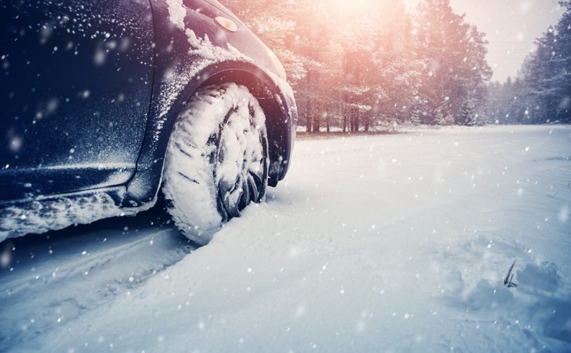 Car tires on winter road covered with snow